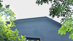 Un edificio moderno con fachada oscura, una ventana y una pequeña entrada.