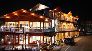 A multi-story wooden building with balconies and large windows, likely a hotel or resort.