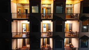 A multi-story building with balconies and windows, featuring a modern architectural style with brick and wooden elements.