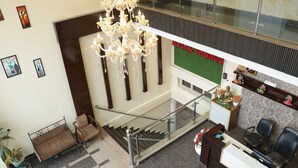 A hotel lobby with a staircase, a reception desk, and a chandelier. - Hotel Royal Palace Jalandhar (Jalandhar)