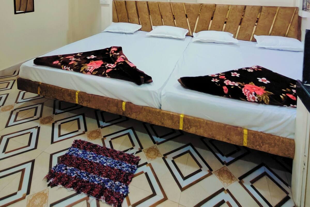 A bedroom with a bed, a ceiling fan, and a patterned floor.