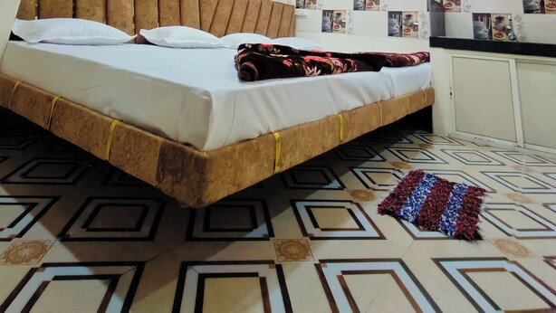 Une chambre à coucher avec un lit, un ventilateur de plafond et un mur décoré de photos.