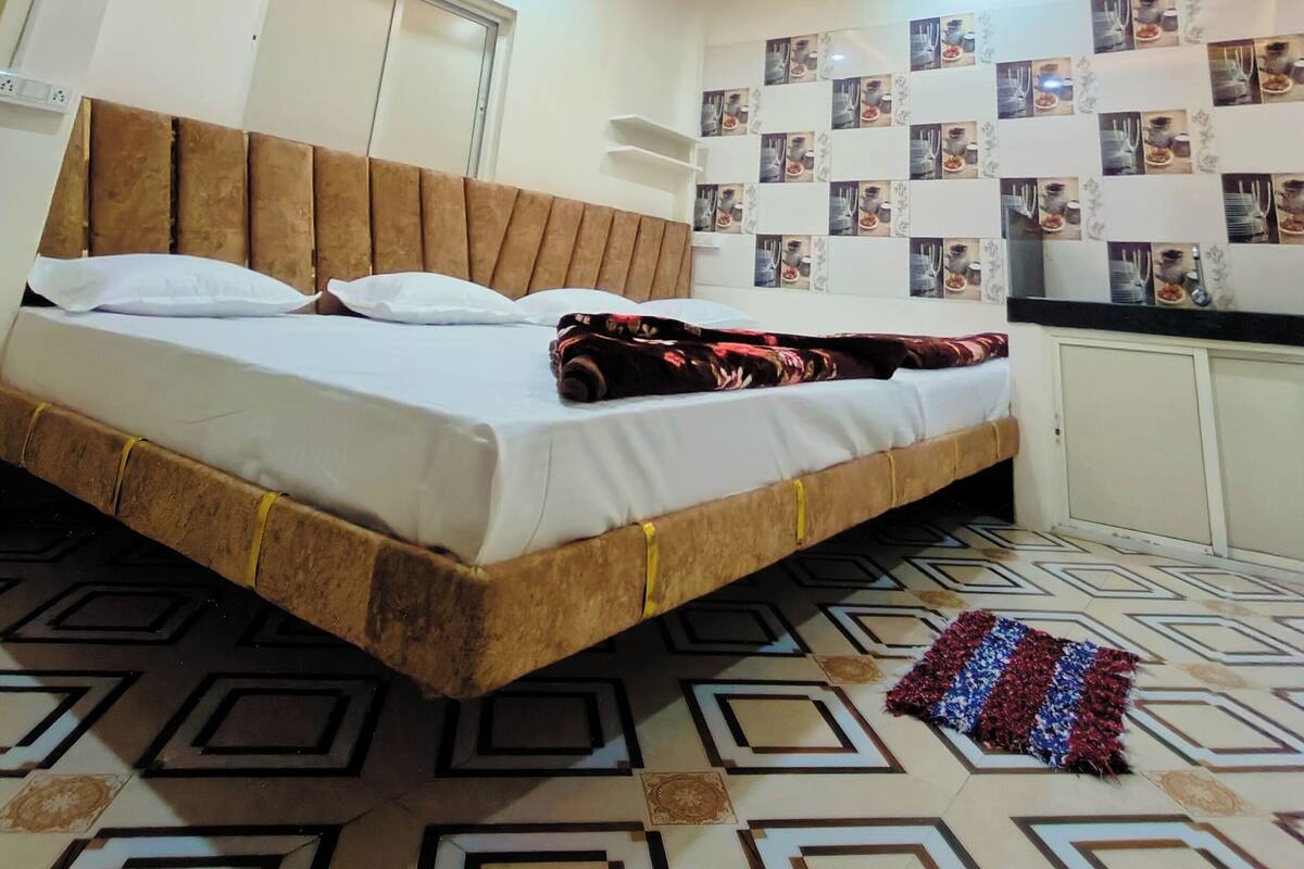 A bedroom with a bed, a ceiling fan, and a wall with photos.