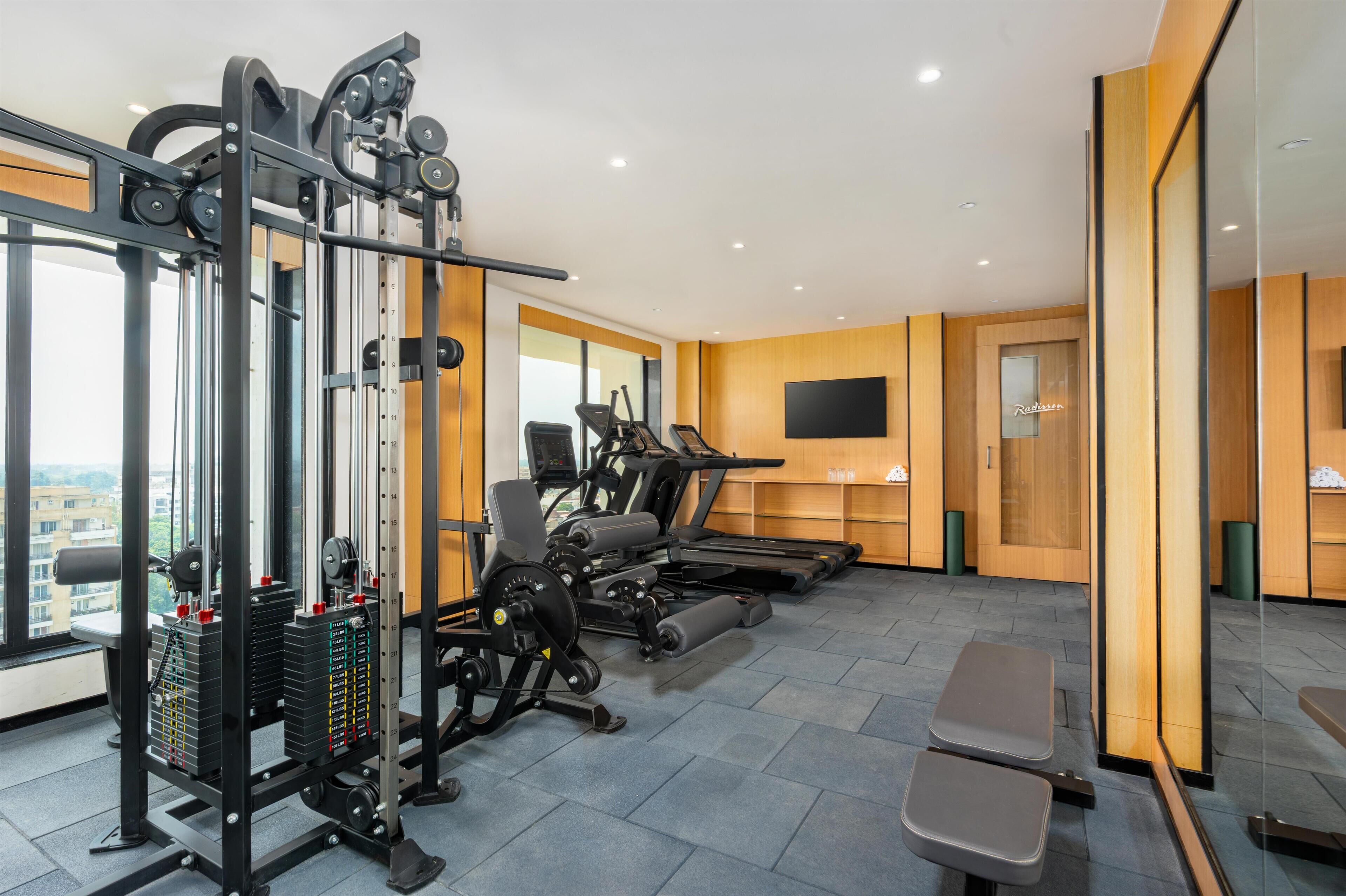 Ein modernes Fitnessstudio mit Kraftgeräten, Laufbändern und Bänken.