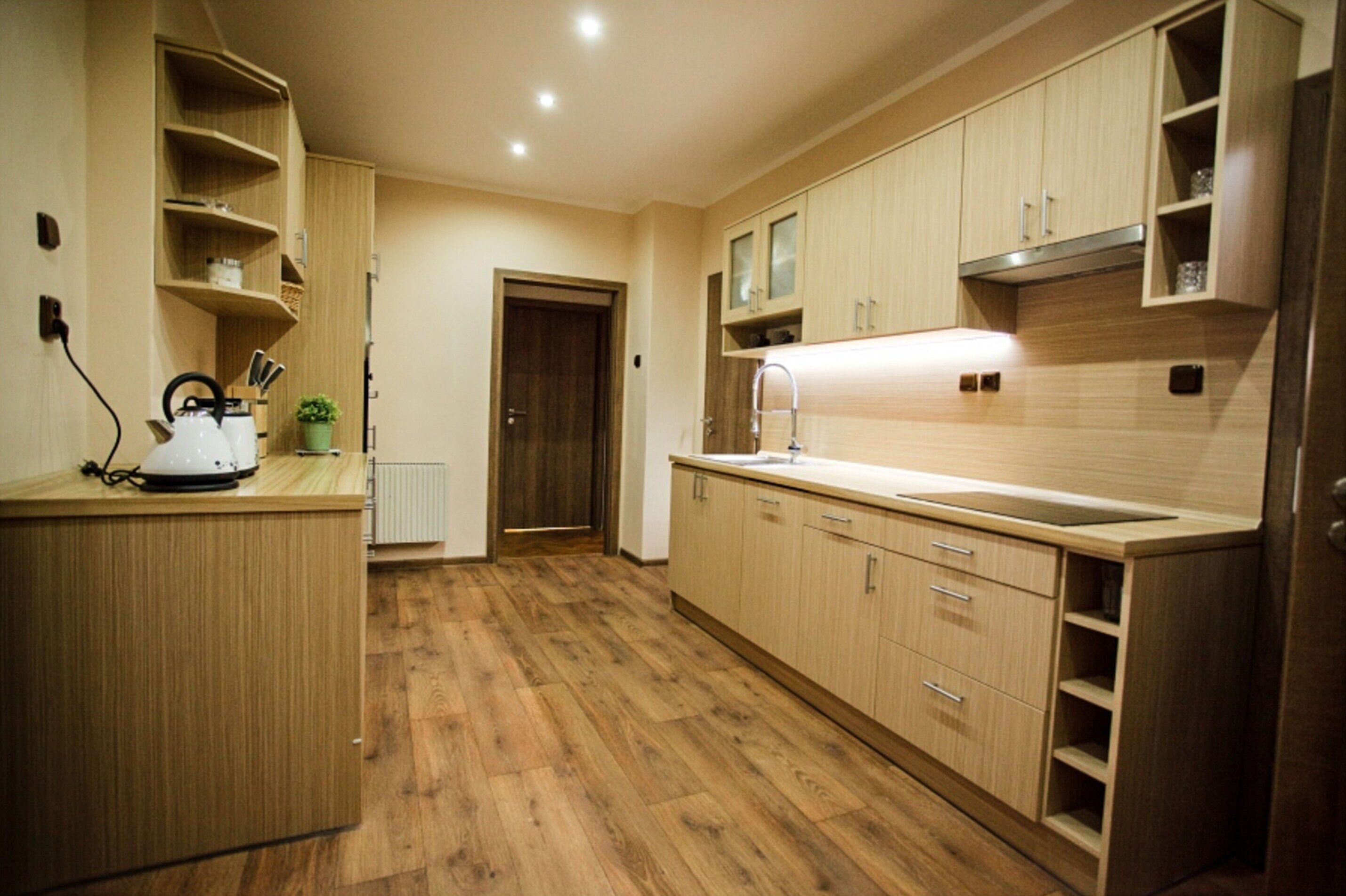 Una cocina moderna con armarios de madera, una encimera y un horno empotrado.