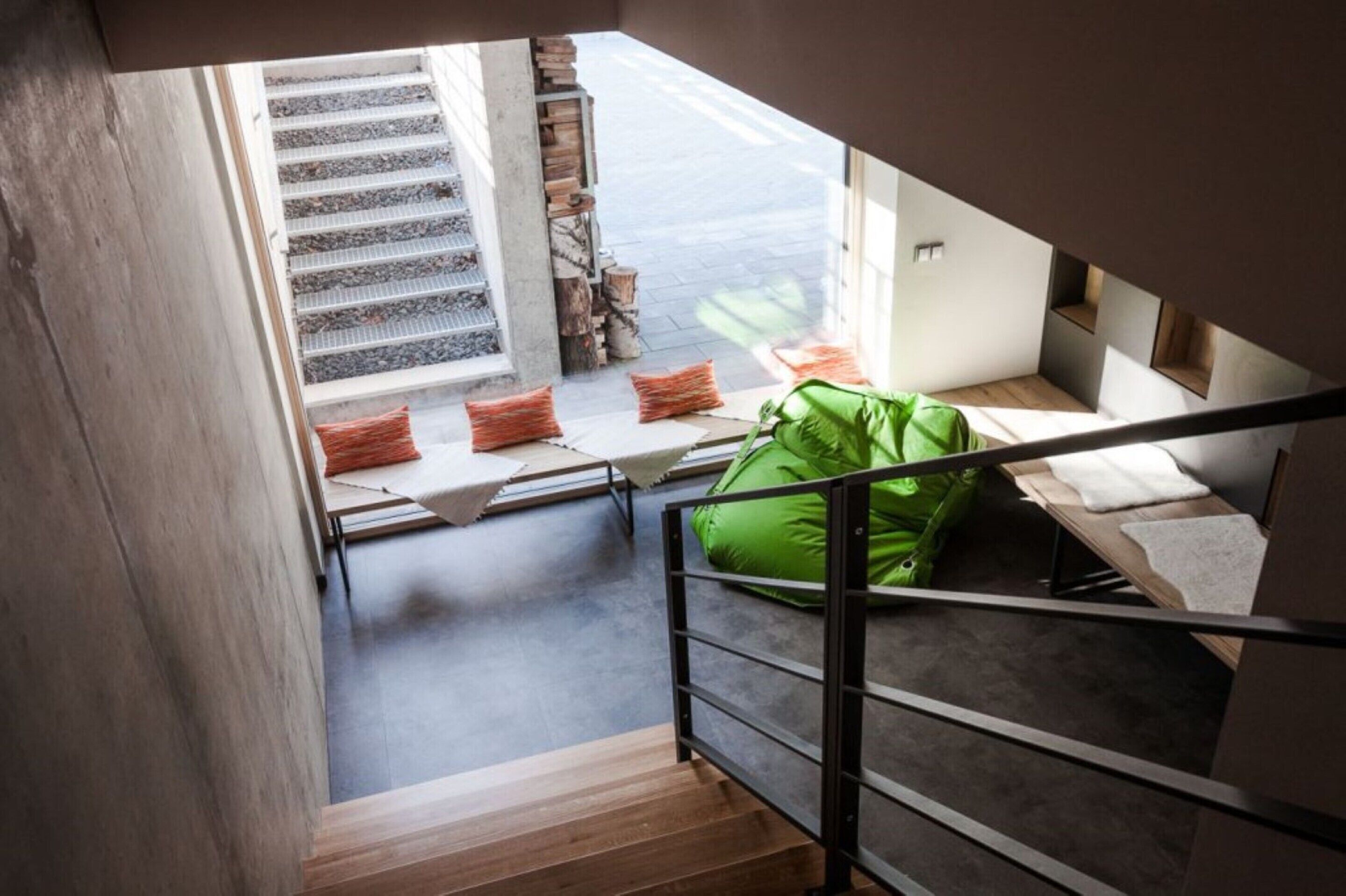 Un dormitorio tipo loft moderno con una escalera que lleva a un balcón.