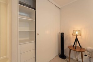 A room with a closed white door, a standing lamp, and a black floor lamp. - Chic Studio in Santiago Centro with City Views! (Santiago)