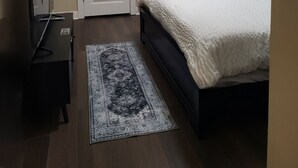 A bedroom with a bed, a ceiling fan, a rug, and two doors. - Modern home in quiet cul-de-sac near University of South Alabama! (Mobile)