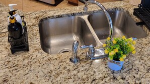 A kitchen with a stainless steel sink, a stove, and a microwave. - Modern home in quiet cul-de-sac near University of South Alabama! (Mobile)