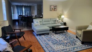 A living room with a sofa, chairs, a coffee table, and a patterned rug. - Modern home in quiet cul-de-sac near University of South Alabama! (Mobile)