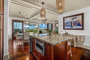 A spacious kitchen with a large island, modern appliances, and a view of the outdoors.