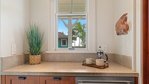 A kitchen with a window, a coffee maker, and a plant.