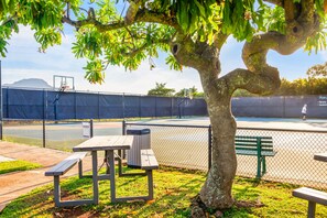 A tennis court with a picnic table and benches, surrounded by a chain-link fence. - Hale Akea by Alekona Kauai: Charming 3br Cottage w AC, Ocean Views, Spa, large yard (Koloa)