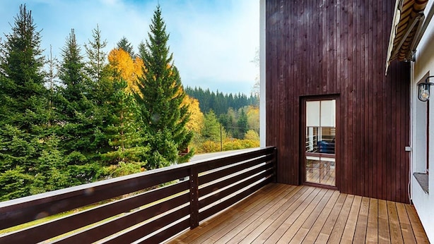A wooden deck with a railing overlooking a forested area. - Apartment in Harrachov With Barbecue (Harrachov)