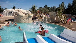 A water park with a pool, slides, and rock formations. - Domaine du Collet (Les Moutiers-en-Retz)