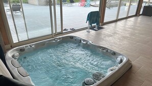 Un bain à remous avec vue sur le patio extérieur, grâce à de grandes fenêtres.