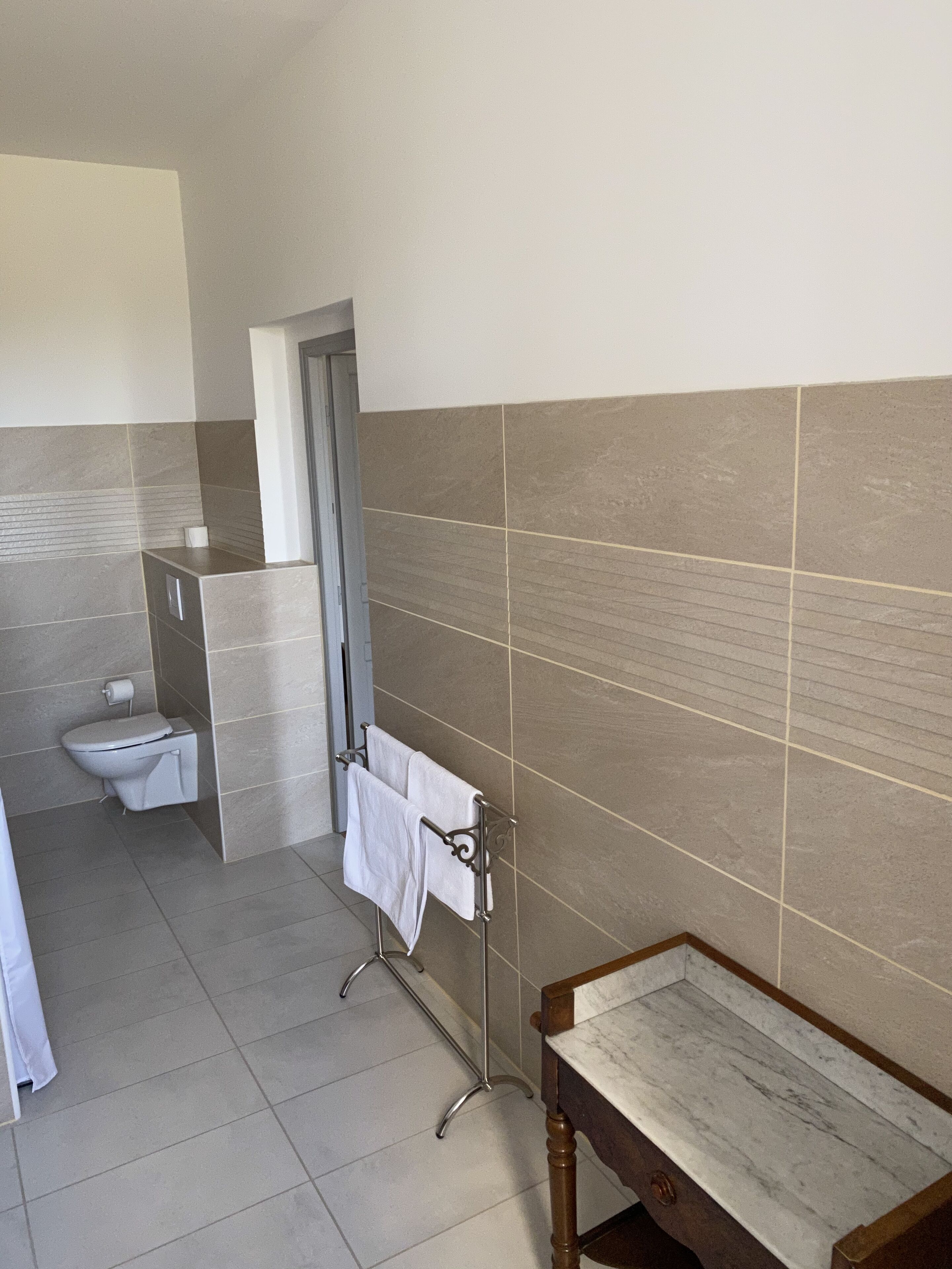Une salle de bain comprenant des toilettes, un lavabo et un meuble-lavabo avec un miroir.