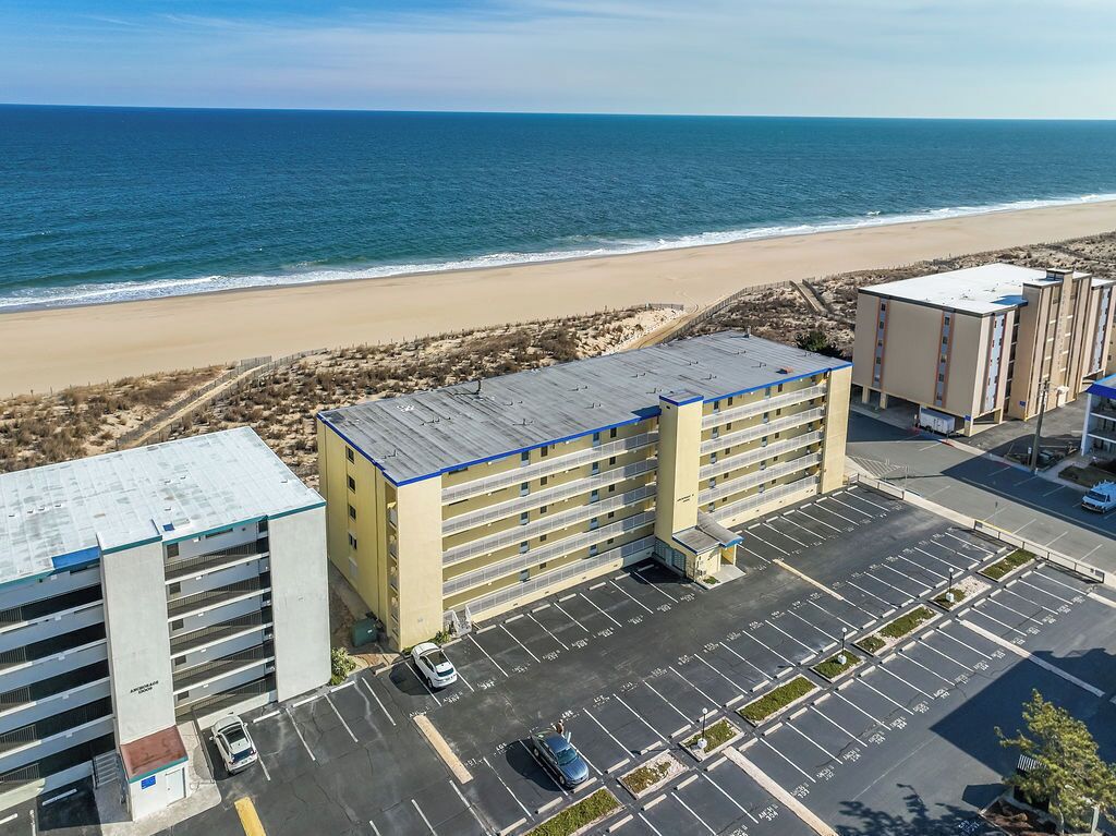 A multi-story parking garage adjacent to a beach, with a clear view of the ocean.