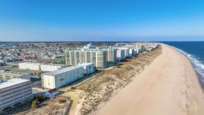 A coastal hotel with multiple high-rise buildings, a sandy beach, and a clear view of the ocean.