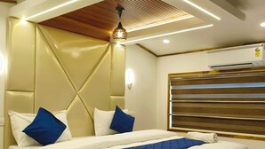 A modern bedroom with a bed, headboard, and ceiling lights. - Vinayak House Boats (Alleppey)
