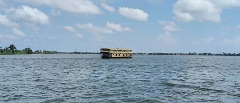 A houseboat on a calm body of water with a clear sky.