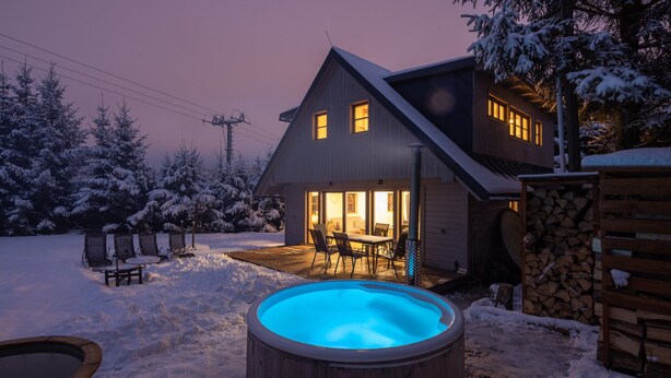 A house with a swimming pool, outdoor seating, and snow-covered surroundings.