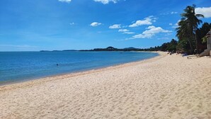A beach with clear blue water, sandy shore, and palm trees. - Lemon House apartment (Koh Samui)