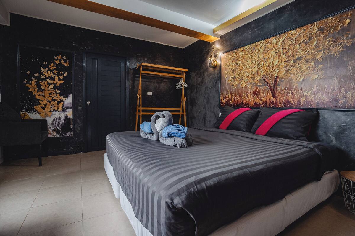 Un dormitorio moderno con una cama grande, una escalera de madera y un mural en la pared.