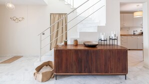 Eine moderne Küche mit einer Holztheke, Edelstahlgeräten und Blick auf den Wohnbereich.