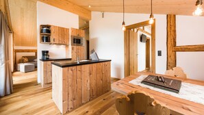 A modern kitchen with wooden cabinetry, a central island, and pendant lighting. - Erholungswelt Lechrefugium (Steeg)