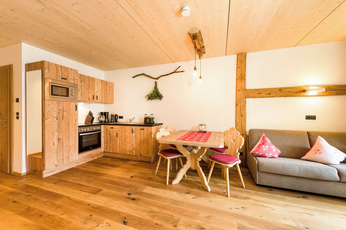 Un intérieur en bois comprenant une cuisine, un coin repas et un espace salon.
