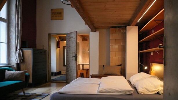 Une chambre confortable avec un lit, une commode et une fenêtre avec des rideaux.