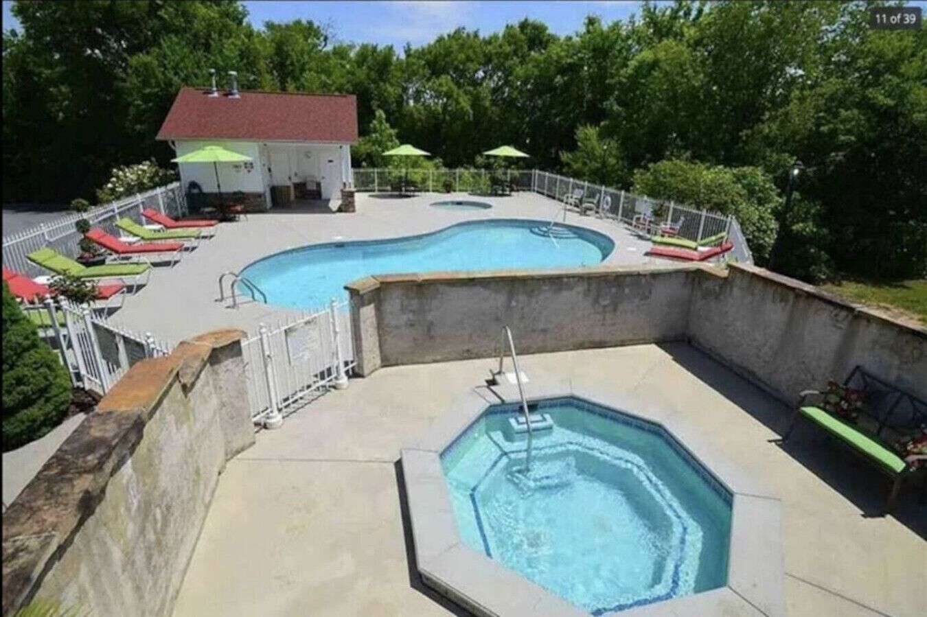 Ett poolområde med två pooler, en överbyggd sittplats och en liten byggnad.