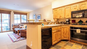 A kitchen with wooden cabinets, a dishwasher, a microwave, and a large oven.