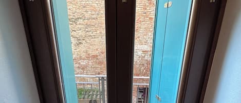 A skylight with a view of a brick wall and a blue door.