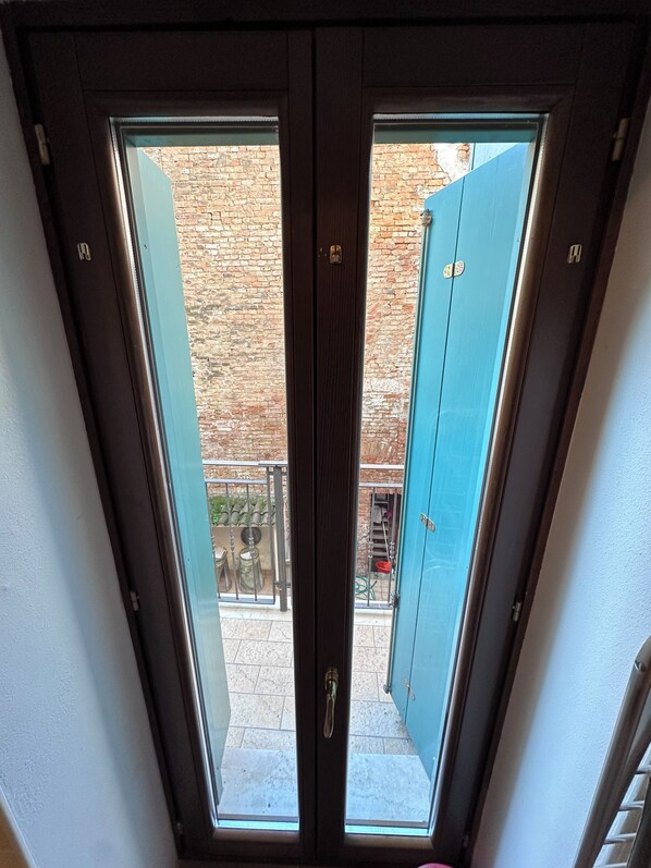 A skylight with a view of a brick wall and a blue door.