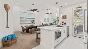 A modern kitchen with a central island, pendant lights, ceiling fans, and a view to the outside. - NEWLY REMODELED-QUIET LOCATION-AC-WELL EQUIPPED-METICULOUS CLEANING (Wailea)