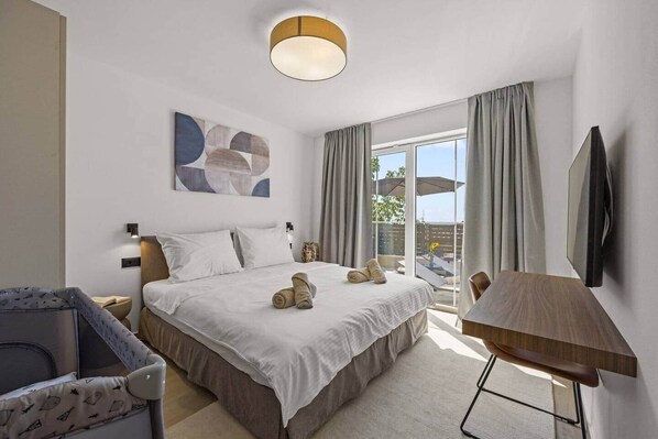 A hotel room with a bed, a chair, a TV, and a balcony with curtains. - Villa Bella Vista with Pool and Seaview (Kaštelir)