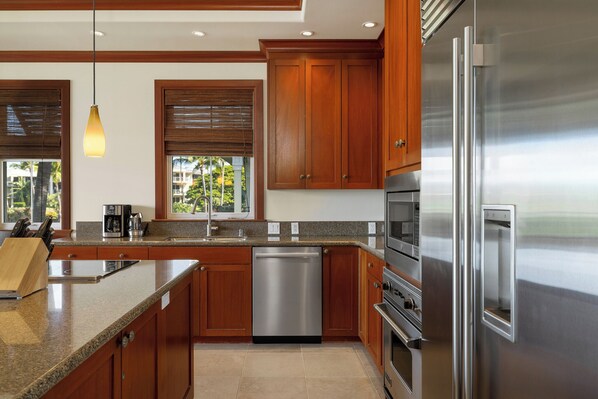 Una cocina moderna con armarios de madera, electrodomésticos de acero inoxidable y encimera de granito.