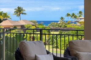 Ein Balkon mit Blick auf den Ozean und tropische Vegetation.