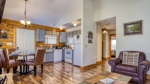 A spacious living area with a dining table, chairs, a sofa, and a coffee table. - Greenbrier Woods 2 Bedroom Cabin (Gatlinburg)