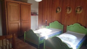 A room with two green beds, wooden wardrobe, and a chair. - Quiet house for rent (Saint-Marcel-d'Ardèche)