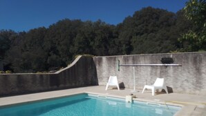 A swimming pool with clear water, surrounded by a concrete deck. There are two white lounge chairs and a metal railing along the edge. - Quiet house for rent (Saint-Marcel-d'Ardèche)