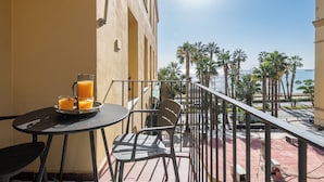 A balcony with a table, chairs, and a tray of orange juice. - Solaga - Gutenberg Beach (Málaga)