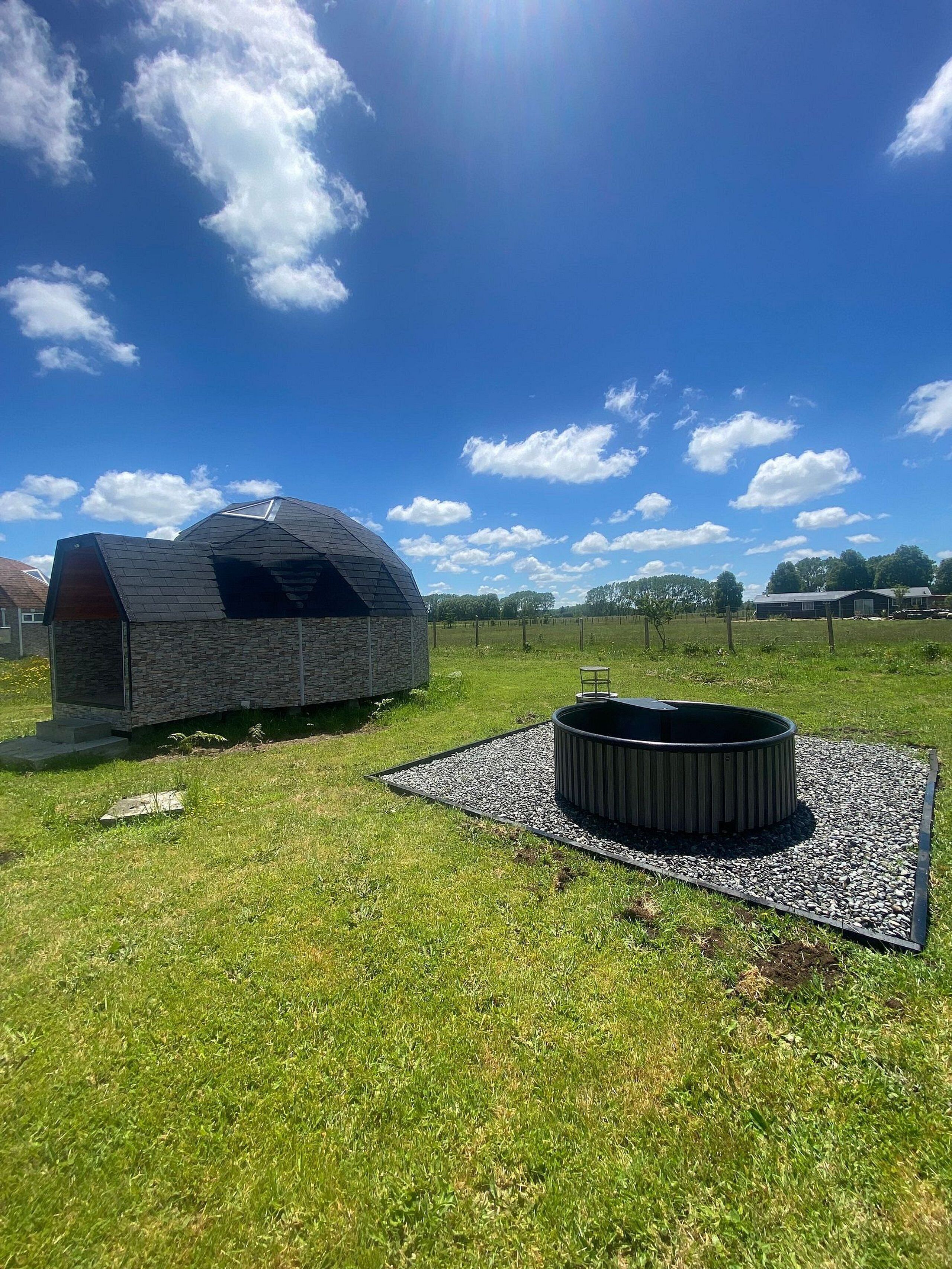 Une maison moderne dotée d’un toit en forme de dôme original et d’un jacuzzi dans le jardin.