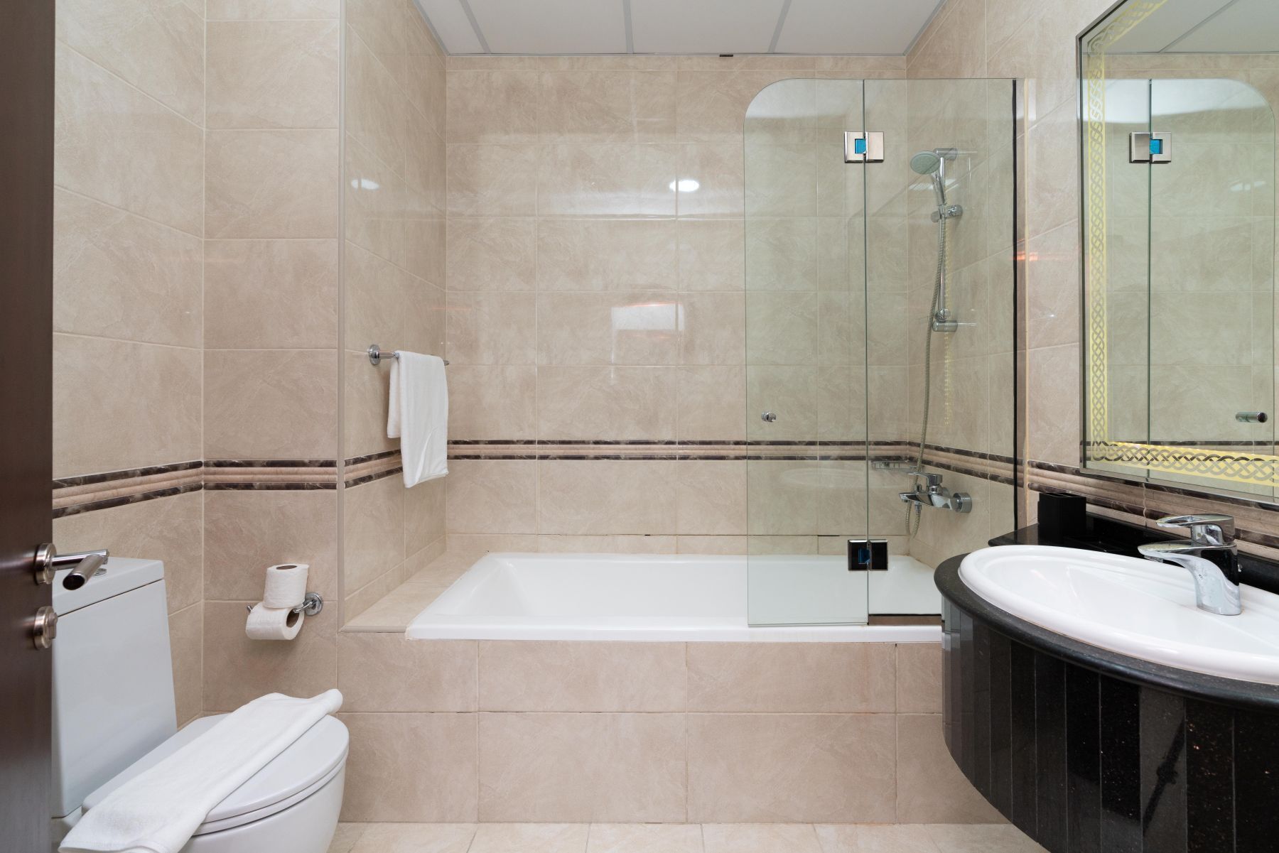 Un baño moderno con ducha envuelta en vidrio, una bañera y un tocador con lavamanos.