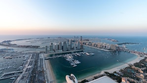 An aerial view of a coastal city with high-rise buildings, a marina, and a beach. - 4BR Maid Penthouse w Pool and Jacuzzi (Dubai)