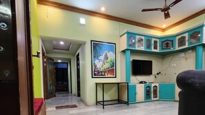 A spacious living area with a tiled floor, a ceiling fan, and a painting on the wall. - Holiday Home - GF 3BHK Full House (Madurai)