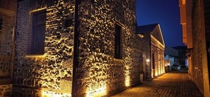 A narrow cobblestone street at night with illuminated stone buildings. - Mihman Konak Hotel (Kars)
