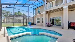 A swimming pool with a glass enclosure, a covered patio, and a second-story balcony with outdoor seating. - Unique, 7 bed Luxury Disney Escape, Theater & Heated Pool (Davenport)